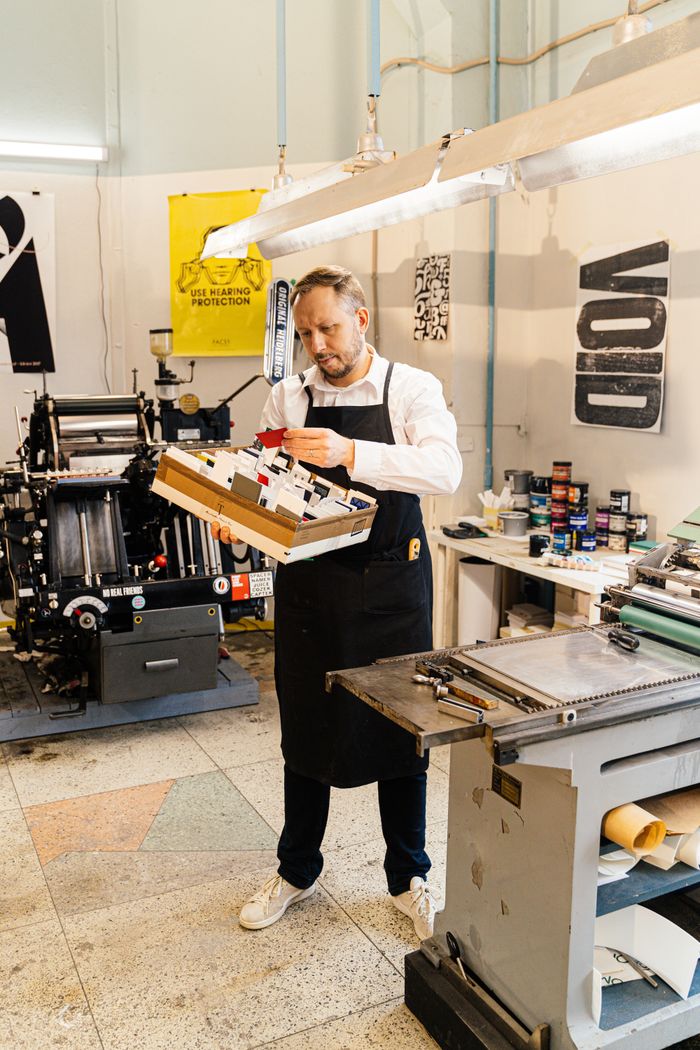 Mastering the First Impression: Your intriguing post title goes here Adult man examining prints in an industrial workshop, highlighting craftsmanship.